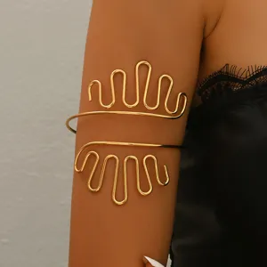 Primo piano sui dettagli del bracciale da braccio geometrico dorato in stile punk.