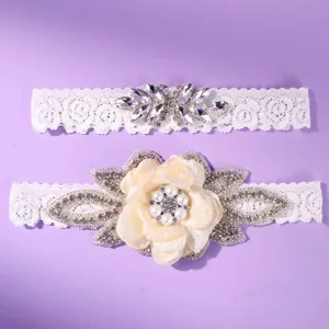 Elegant white lace wedding leg garters set with shimmering rhinestones and pearls, bridal accessories.