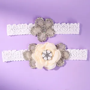 Elegant white lace garter belt set with sparkling rhinestones and pearls for wedding party.