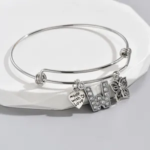 Detail shot of adjustable silver letter W and butterfly charm bracelet with rhinestones.