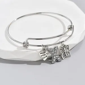 Adjustable silver-tone charm bracelet featuring a rhinestone letter X, heart, and butterfly.