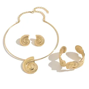 Set di gioielli dorati con texture conchiglia, collana girocollo, orecchini e bracciale rigido aperto.