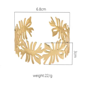 Bracciale manchette aperto dorato con intricata trama cava a onda, gioiello da polso largo ed elegante.