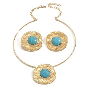 Exaggerated vintage turquoise pendant collar necklace set with gold tone metal design.