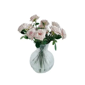 Vaso in vetro trasparente con design a coste e bellissime rose rosa per decorazione d'interni.