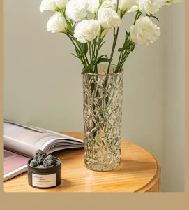 Transparent glass flower vase for home decor, elegant crystal textured tabletop floral arrangement container.