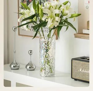 Transparent iridescent glass vase detail showcasing geometric faceted crystal surface with lilies.