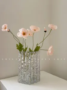 Transparent textured glass vase with pink artificial flowers for home living room decor
