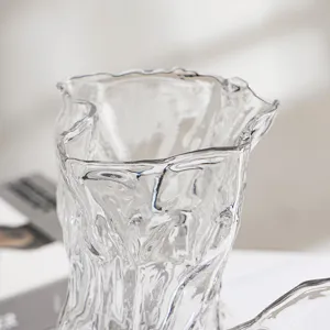 Vaso in vetro trasparente con design ondulato irregolare, ideale per arredamento moderno.