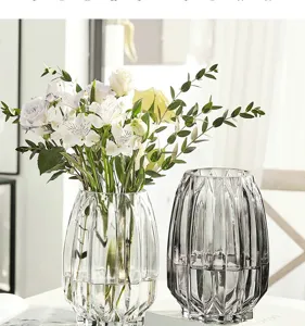 Detail shot of faceted glass vases with fresh flowers, elegant table decor and transparent finish.