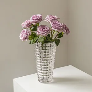 Transparente strukturierte Glasvase mit lila Rosen für elegante Heimdekoration im Wohnzimmer.