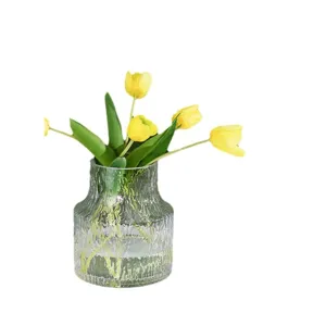 Transparent glass glacier textured vase with yellow tulips, perfect for living room table decor.