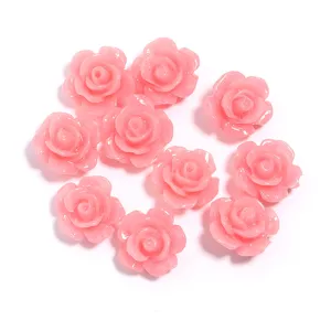 Detailed shot of pink resin rose flower cabochons for DIY phone case and jewelry making.