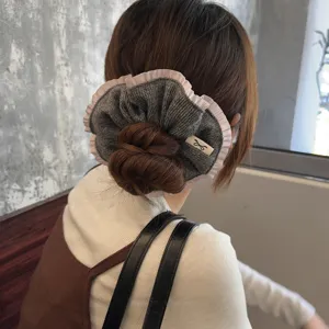 Grey knitted hair scrunchie with pink ruffle trim, elegant wool hair accessory for women bun.