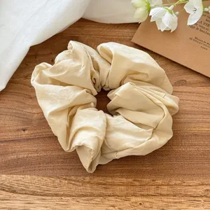 Detailansicht eines einfarbigen, beigen Bubble-Haargummis, weicher Stoff für süßes Styling.