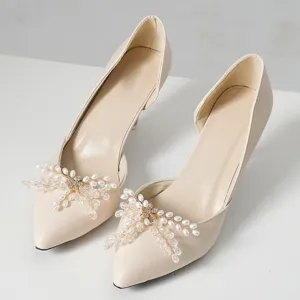 Elegant beige pointed high heels featuring delicate pearl crystal bow toe decorations.