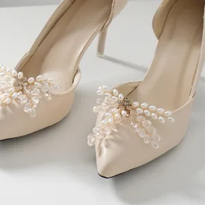 Close-up detail of elegant pointed toe high heels adorned with sparkling pearl crystal shoe clips.