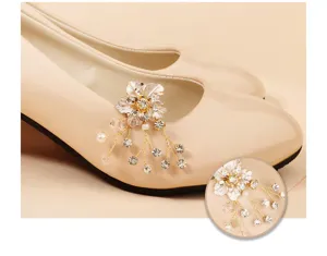 Detailansicht des funkelnden Strassblumen-Schuhclips und Perlenquasten auf schicken Pumps.