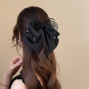 Detailaufnahme der wunderschönen eleganten schwarzen Haarschleife mit feinen Perlenakzenten.
