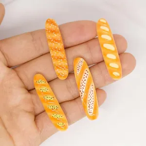 Breloques baguette résine miniature gros plan détails, accessoires artisanaux pour maison de poupée.