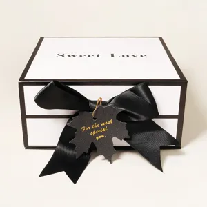 Detailansicht der Luxus-Geschenkbox mit schwarzer Schleife und dekorativem Anhänger für Geschenke.