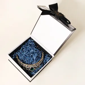 Exquisite Geschenkbox mit blauem Füllmaterial und Vintage Strass Krone, perfektes Präsent.