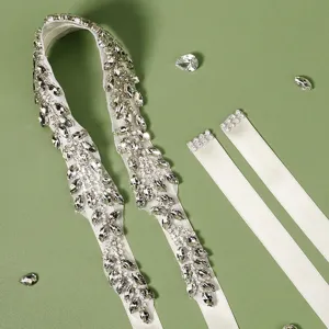 Detail view of luxurious handmade bridal rhinestone belt with sparkling crystals and white ribbon.