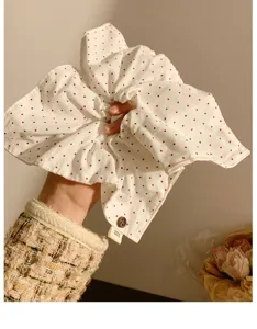 Primo piano dettagliato dello scrunchie per capelli quadrato a pois bianchi in stile coreano.