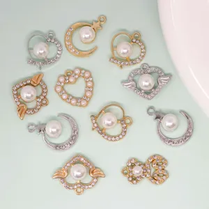 Gros plan de pendentifs de bijoux en métal cœur lune strass perle DIY, détails accessoires.