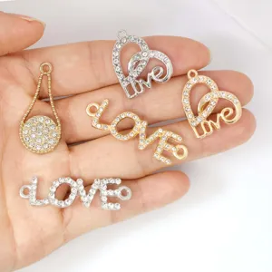 Nahaufnahme von Legierung Strass Liebe Anhängern und Verbindern für DIY Armbänder Ketten.