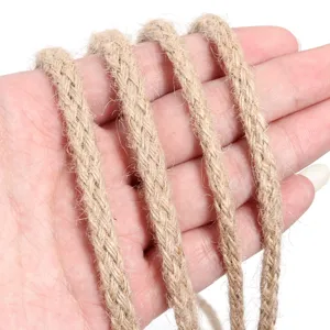 Detail shot of thick natural jute rope coiled neatly in hand, showing fine texture.