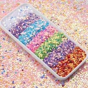 Gros plan détaillé de sequins cœur holographiques colorés de 3 mm pour nail art et loisirs.