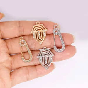 Detailed view of alloy rhinestone shield and safety pin jewelry pendants, perfect for DIY crafts.