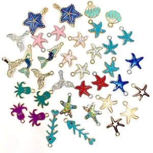 Primer plano de dijes de aleación esmaltada estilo marino con detalles de conchas y estrellas.