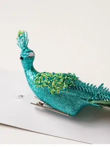 Gedetailleerd shot van glitterende turquoise pauw clip ornament voor kerstboom decor en display.