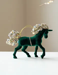 Close-up of the green velvet unicorn Christmas ornament with glittering sequins and hanging cord.