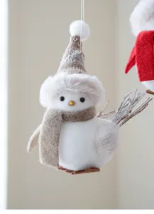 Detailed close-up of a cute plush Christmas bird ornament wearing a knitted hat and scarf.