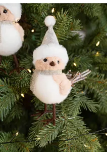 Closeup of Christmas tree hanging ornament featuring a cute plush bird with champagne sparkly hat.