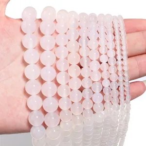 Primo piano di perle tonde in agata naturale liscia per la creazione di gioielli fai da te.