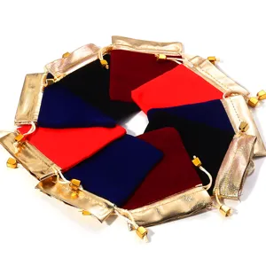 Close-up detail of assorted colorful velvet jewelry pouches with golden borders and drawstrings.