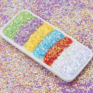 Detail shot of colorful star sequins in a white tray on purple background for nail art.