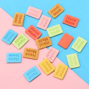 Gedetailleerd overzicht van kleurrijke kunstlederen handgemaakte vierkante labels voor handwerk.