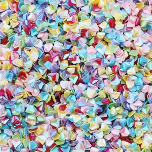 Primo piano di paillettes colorate da 4mm per nail art, dettagli brillanti per decorazioni.