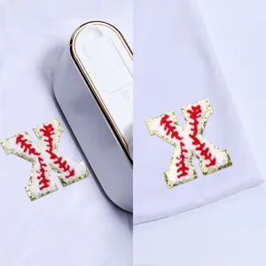 Chenille letter X patch detail shot, baseball style red stitch with gold glitter border for DIY crafts.