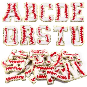 Detailed view of white chenille baseball letter patches with gold glitter borders and red stitching.