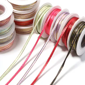 Colorful polyester ribbons with gold edges on spools for gift wrapping and DIY crafts.