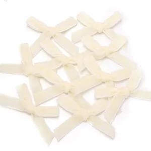 Vue détaillée de nœuds en velour crème, parfaits pour pinces à cheveux et emballages cadeaux.