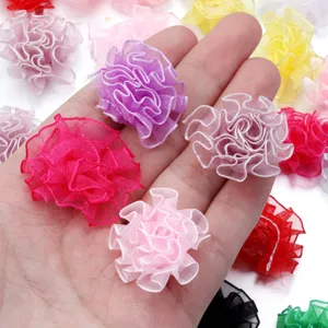Gros plan de fleurs d'œillet en organza faites main de 3.5cm, idéal pour les accessoires.