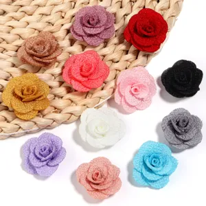 Vista dettagliata di accessori fai-da-te di rose in tessuto glitterato colorato.