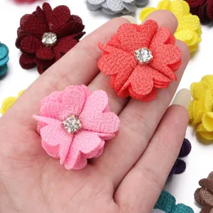 Close-up detail of handmade fabric flower with rhinestone center for DIY apparel accessories.